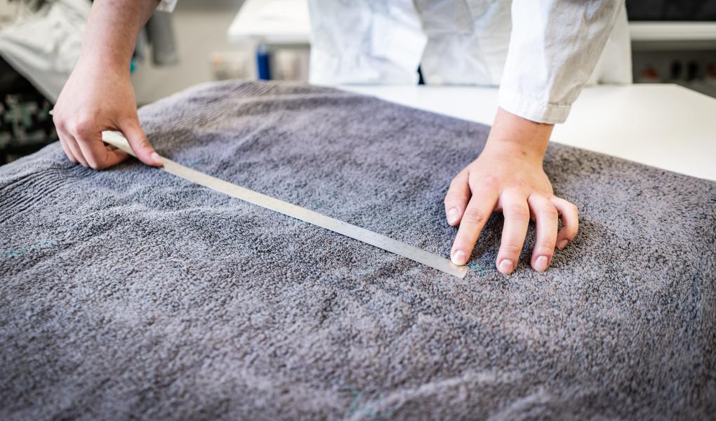 Laboratoriet måler hvor mye håndkleet har krympet etter ti vask og tørking i tørketrommel. Foto: Peter Jülich.